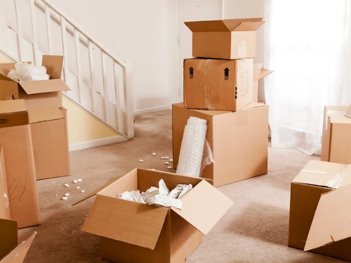 Clasificación de enseres antes de su retirada Cajas abiertas y material de embalaje en el salón de una vivienda en pleno vaciado