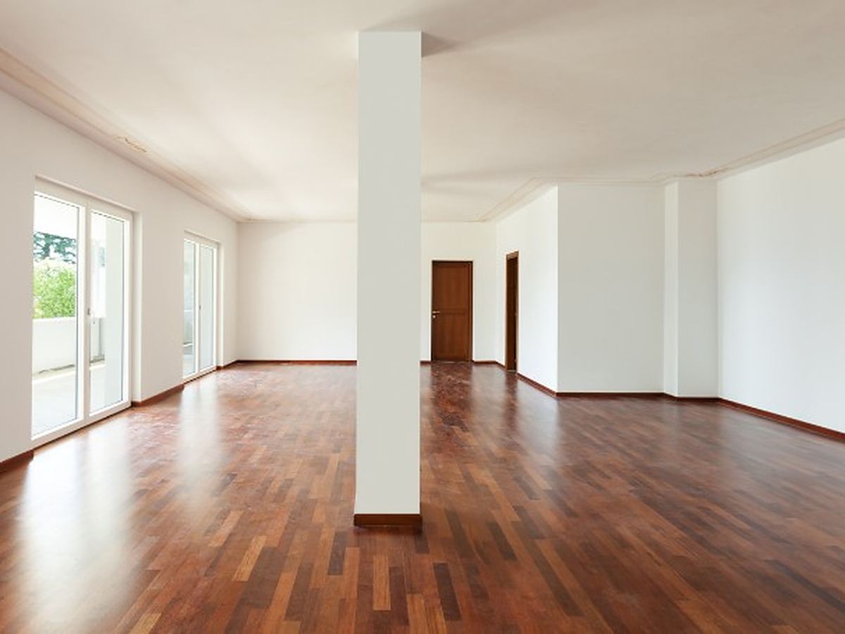 Vaciado de pisos por herencia en Salamanca Salón amplio de un piso heredado, ya vacío, con parquet oscuro y salida a la terraza