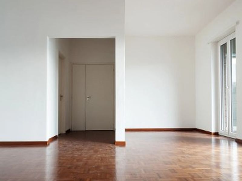 Piso vaciado en Salamanca Salón de un piso vacío con parquet en espiga y puertas blancas